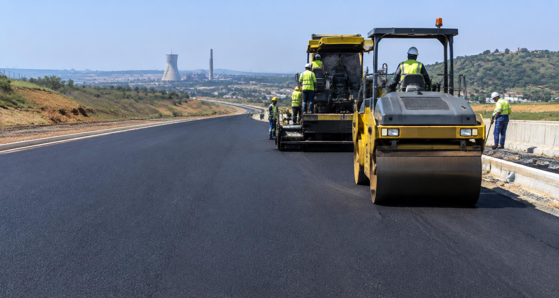 Illustrative road construction with asphalt machinery and safety-equipped workers